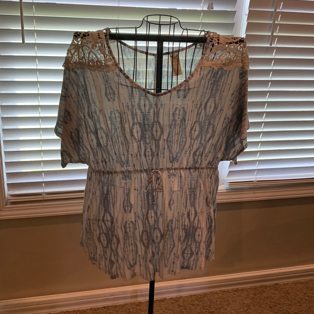 Adorable shirt with a tie waist and lace on the shoulders.